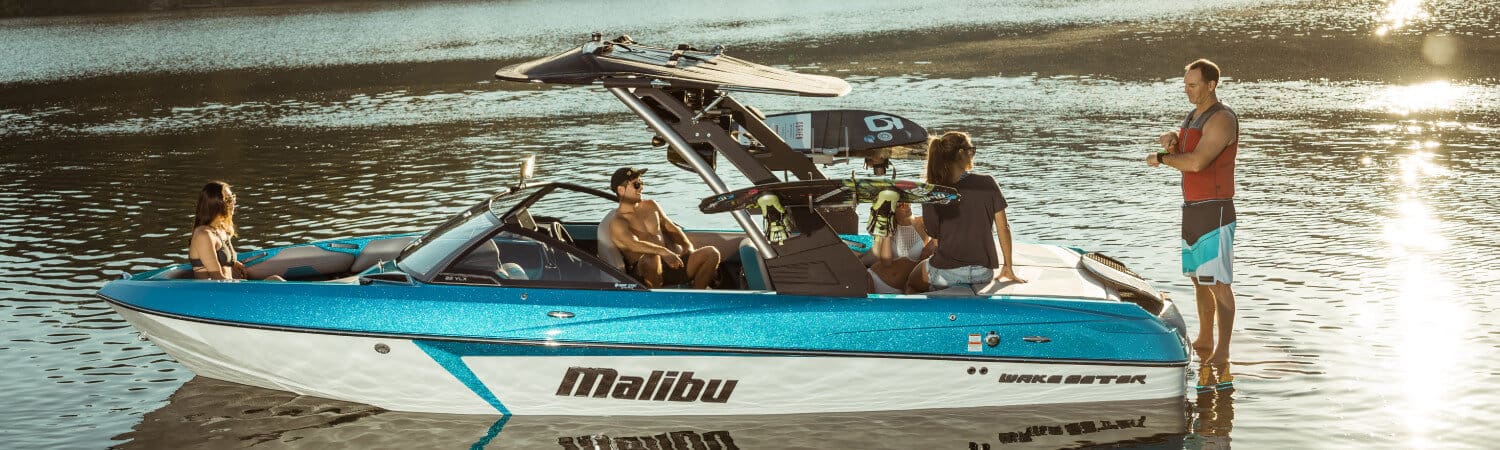 Group of people hanging out on the water on a Malibu wake boat
